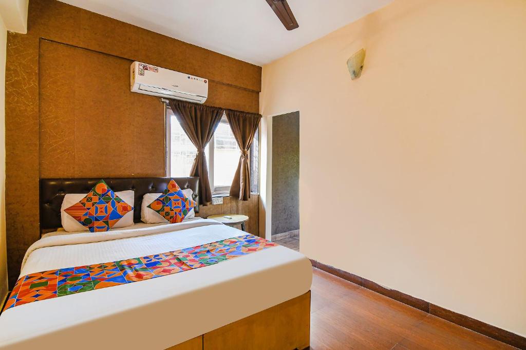 Schlafzimmer mit einem Bett und einem Fenster in der Unterkunft FabExpress Krishna in Kalkutta