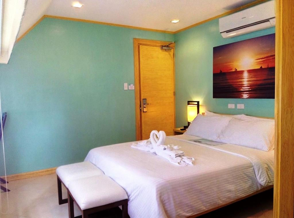 a bedroom with a bed and a wall with a picture at Shore Time Hotel Boracay in Boracay