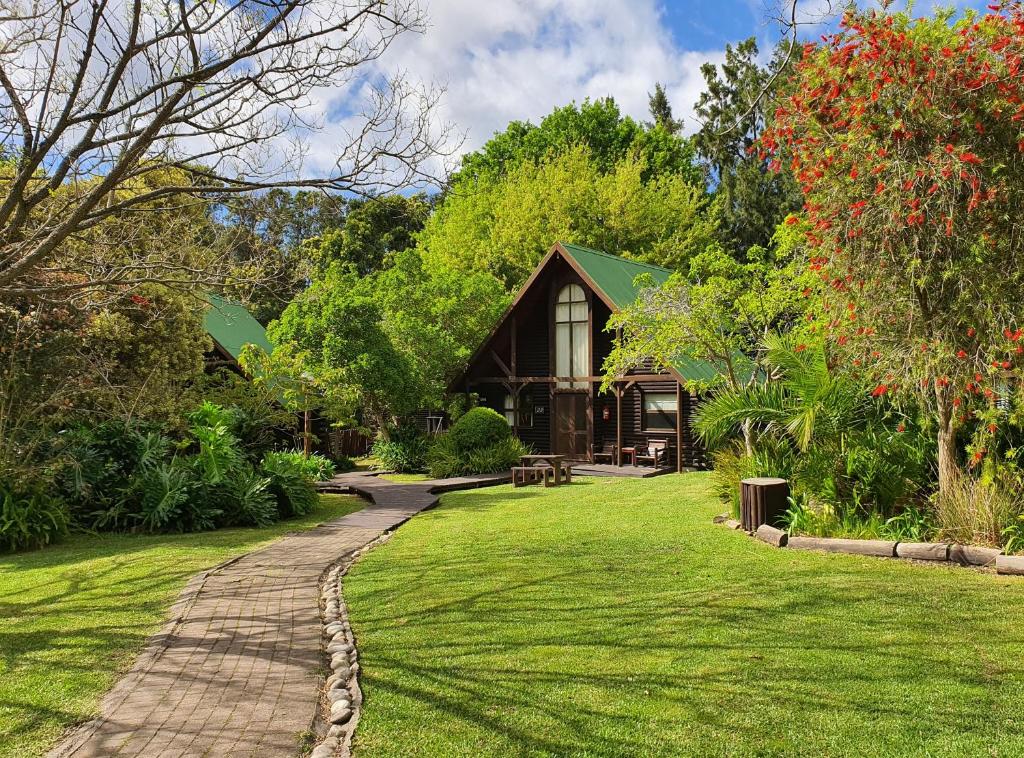 a house with a brick path leading to a garden at Tsitsikamma Lodge & Spa in Stormsrivier