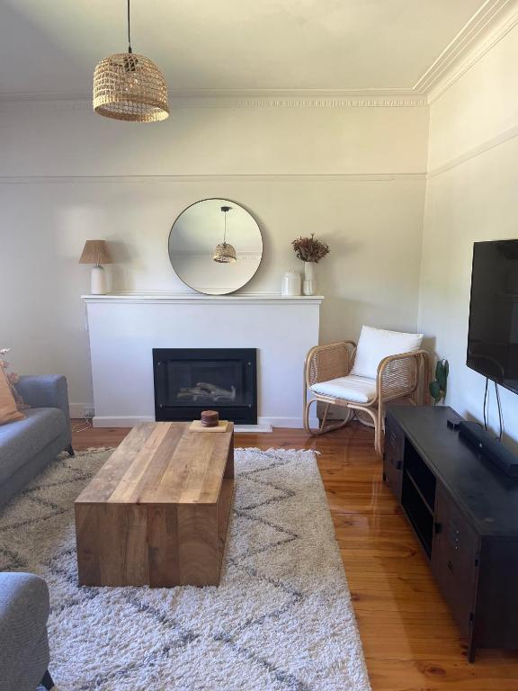 ein Wohnzimmer mit einem Couchtisch und einem Kamin in der Unterkunft Bendigo Goldmines Abode in Golden Square