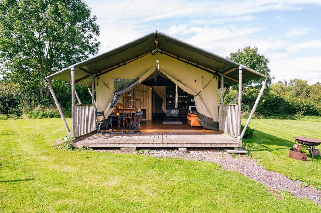 a tent with a wooden deck in a field at Oak in Honiton