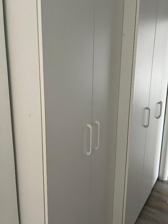 a row of white cabinets in a room at Nice View Apartment in Buzău
