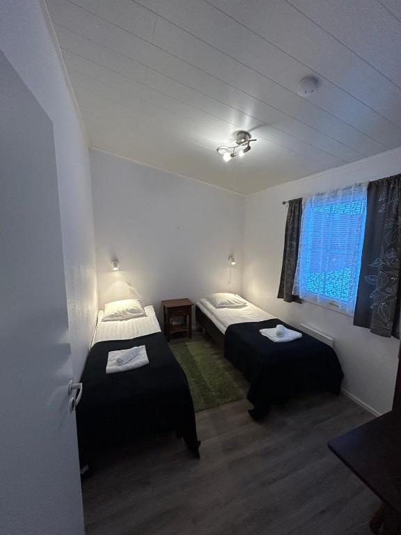 a room with two beds and a window at Ekokatti Cottages in Vuokatti