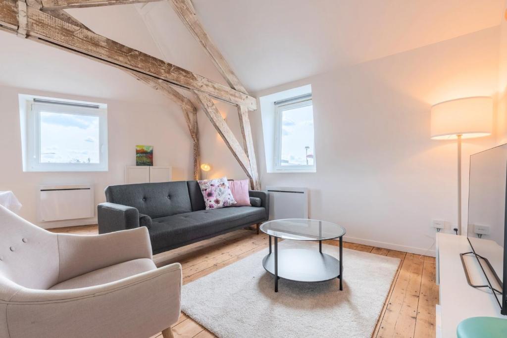 ein Wohnzimmer mit einem Sofa und einem Tisch in der Unterkunft Charming 2-bedroom apartment at Croisé Laroche in Marcq-en-Baroeul
