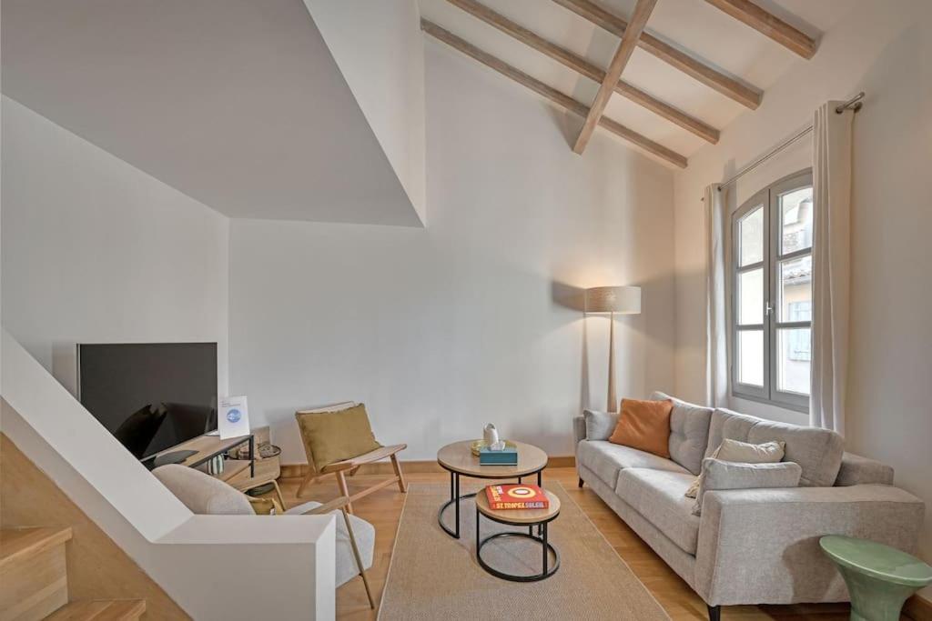 - un salon avec un canapé et une table dans l'établissement Les toits des PAPES - Clim - WIFI - AVIGNON, à Avignon