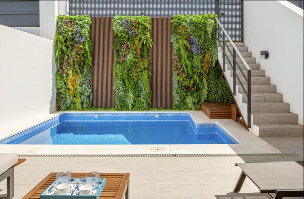 una piscina cubierta con una pared verde y escaleras en Casa Pedro Luis, en Conil de la Frontera