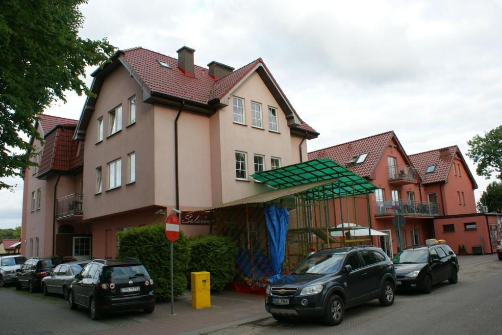 a large house with cars parked in front of it at OWR Grażyna in Międzywodzie