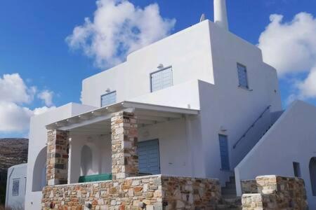 a white building with a cross on top of it at Aeriko Apartment in Paros in Dhragoulás