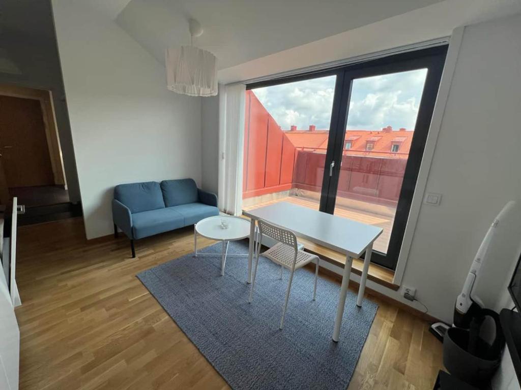 a room with a table and a couch and a window at Private Terrace Apartment in Gothenburg