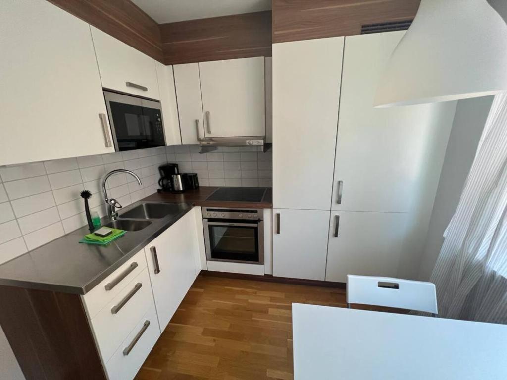 uma cozinha com armários brancos e uma bancada em Elegant Apartment In Lovely Location em Gotemburgo