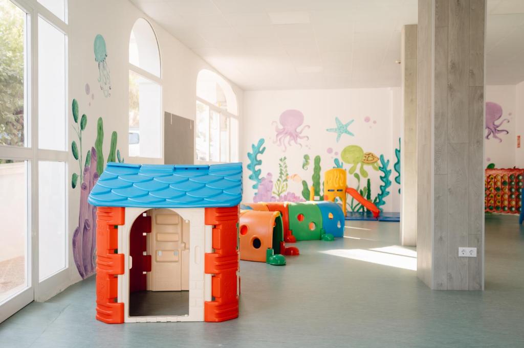 a childrens play room with a toy house at Comitas Floramar in Cala Galdana