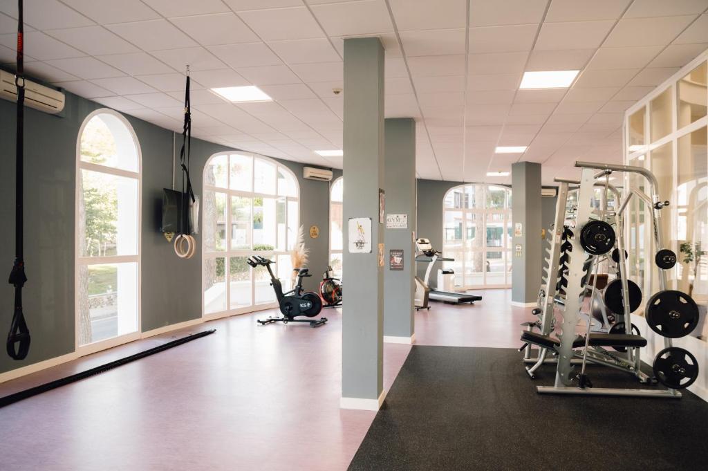 a gym with several treadmills and elliptical machines at Comitas Floramar in Cala Galdana