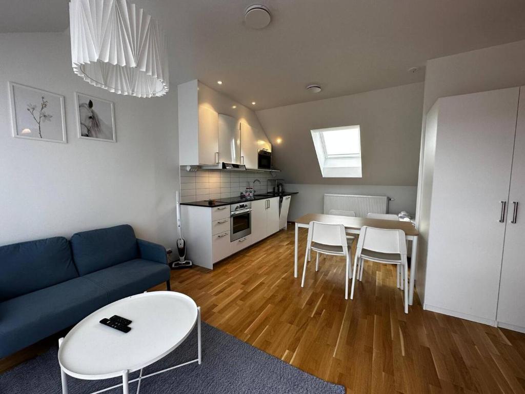 a living room with a blue couch and a table and chairs at Luxurious Apartment With Private Terrace in Gothenburg