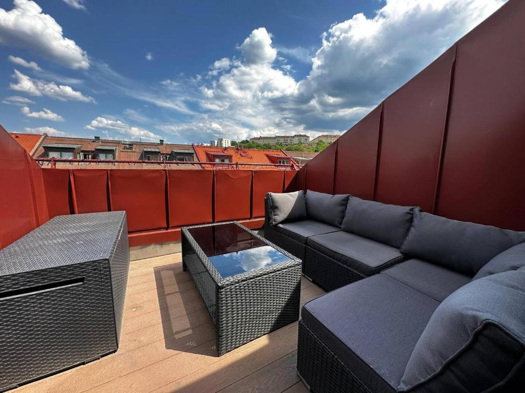 a balcony with a couch and a table on a roof at Luxury Apartment With Private Terrace in Gothenburg