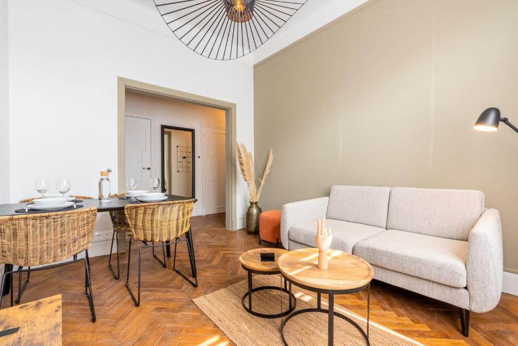 een woonkamer met een bank en een tafel bij Charming and comfortable apartment near tramway in Marcq-en-Baroeul