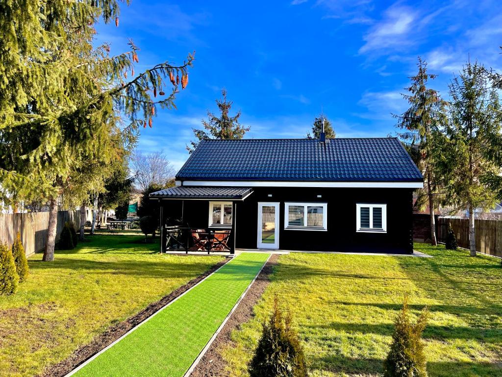 a black house with a blue roof at Vila Scandinavia in Sîngeorgiu de Mureş