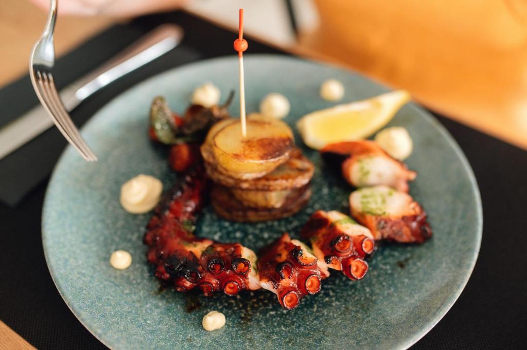 a plate of food with meat and vegetables on a table at Comitas Floramar in Cala Galdana