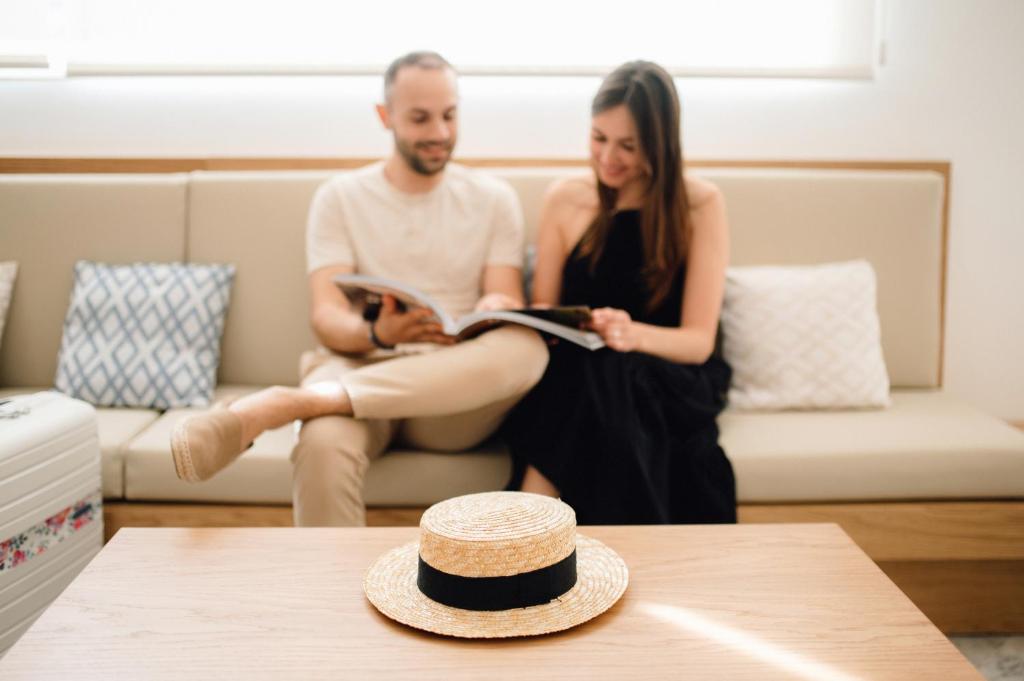 a man and a woman sitting on a couch at Comitas Floramar in Cala Galdana