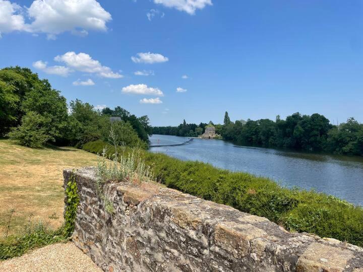 - une vue sur la rivière avec un mur en pierre dans l'établissement La Grande Roche, à Chambellay