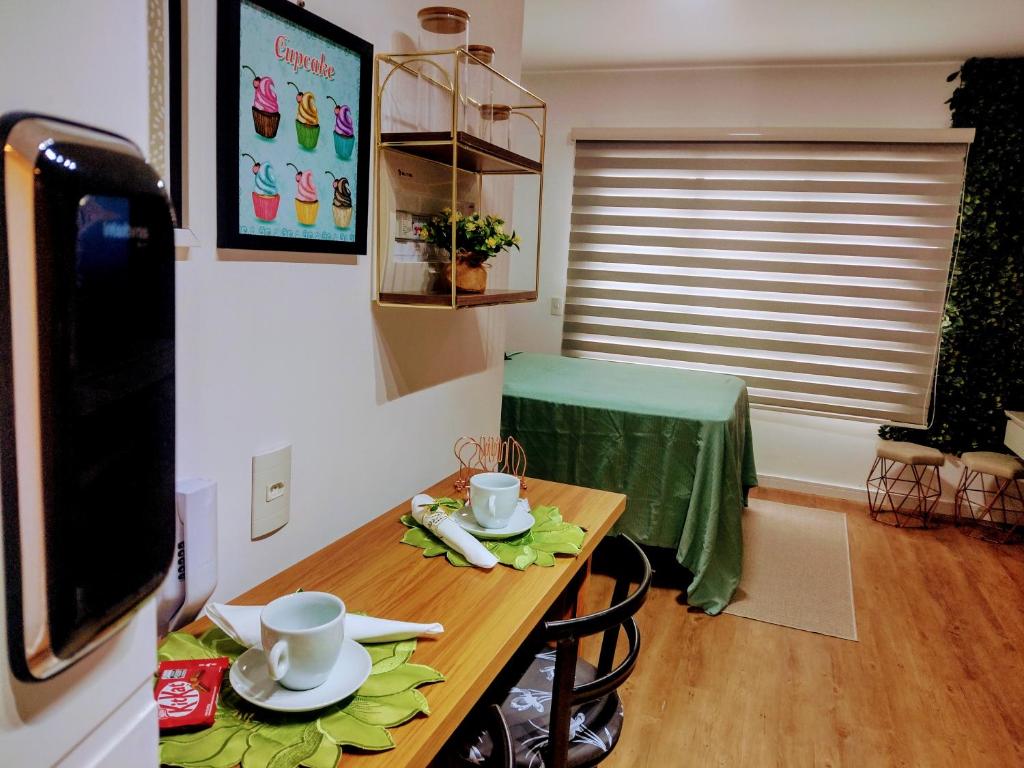 a table with cups and plates on it in a room at Studio novo no Tatuapé ao lado do Metrô Carrão in São Paulo