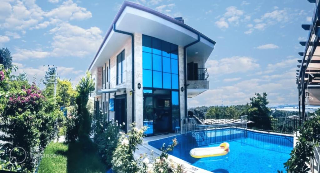 uma casa com uma piscina em frente em Villa15 Lodge, Five-Star Stay 5BD 5-5BA Beach Access Villa with Pool , Gym, Sauna, Alfresco Dining & Garden em Manavgat