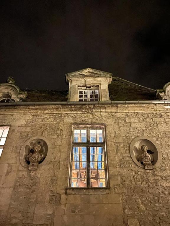 a building with a window on top of it at night at La Maison Saint Joseph in Crépy-en-Valois