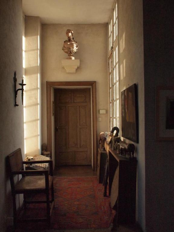 a hallway of a house with a door and a chair at La Maison Saint Joseph in Crépy-en-Valois