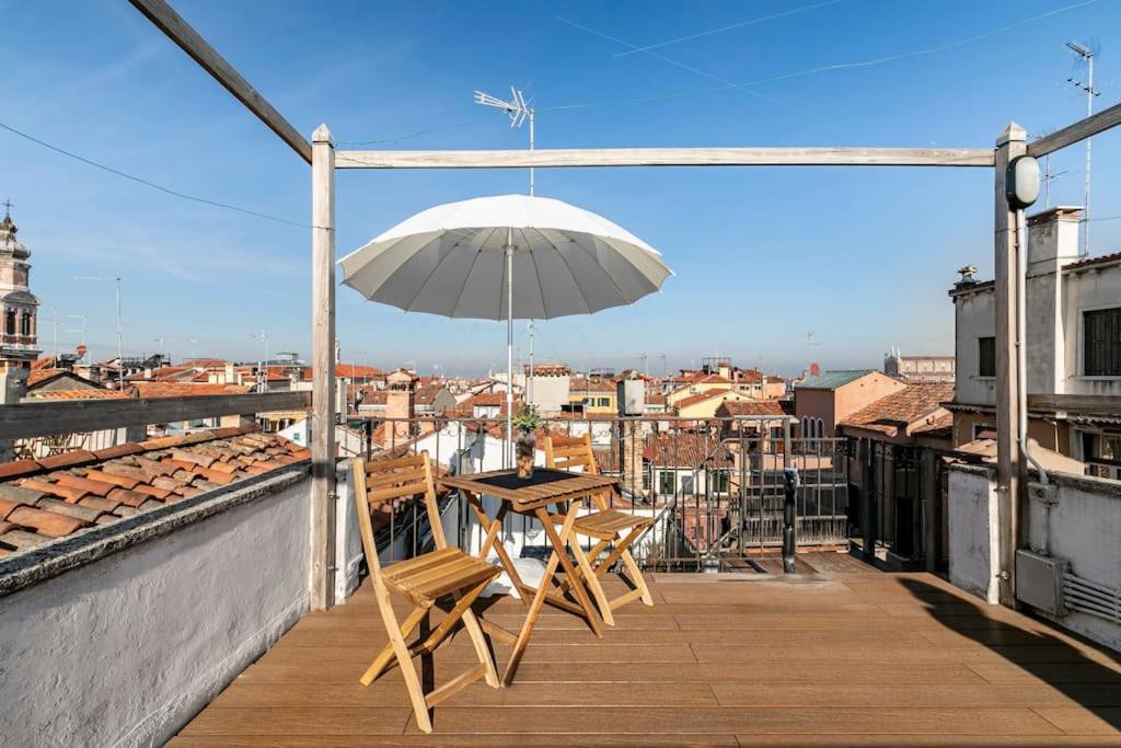 威尼斯的住宿－iHOMES Rialto-Corte del Calice-Attico vista centro，阳台配有桌椅和遮阳伞