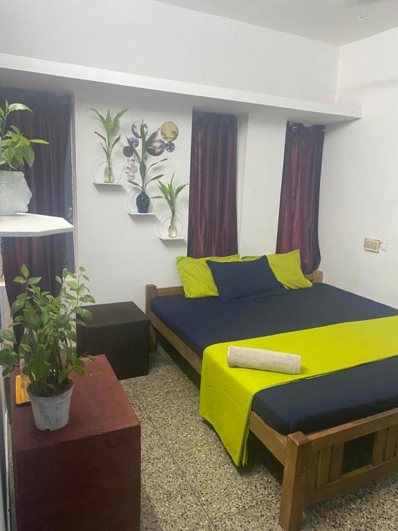 a bedroom with a bed with yellow and blue sheets at Vibes of Varkala Homestay in Varkala