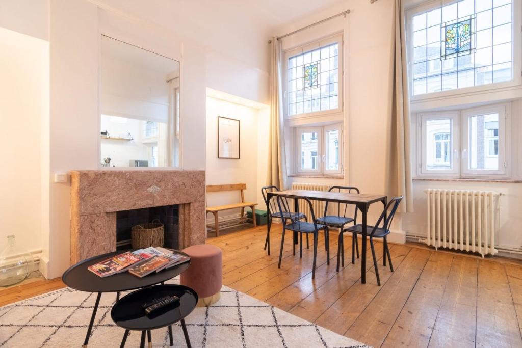un salon avec une table et des chaises et une cheminée dans l'établissement Lille Centre - Nice cozy and functional ap, à Lille