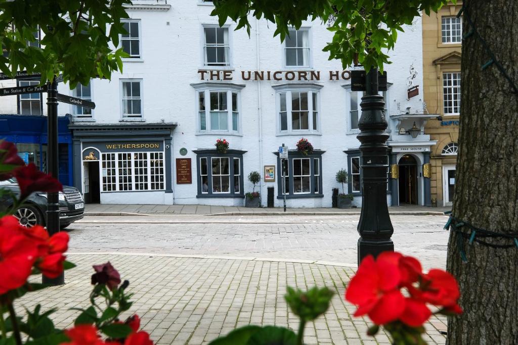 una luz de la calle frente a un edificio blanco en The Unicorn Hotel Wetherspoon, en Ripon