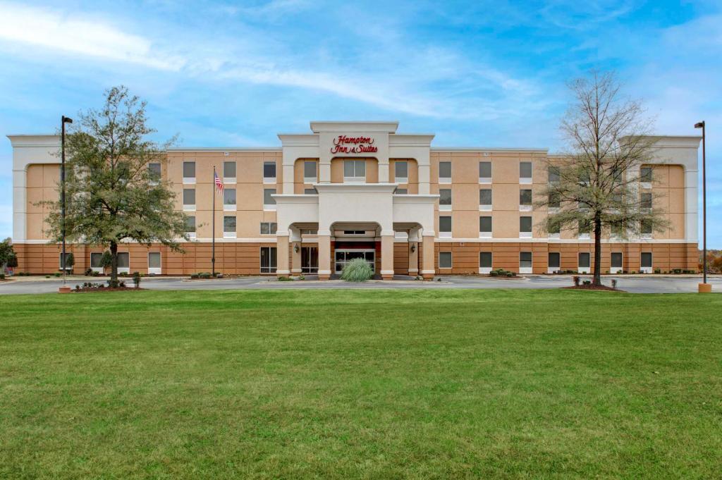 a large building with a lawn in front of it at Hampton Inn & Suites Jackson in Jackson