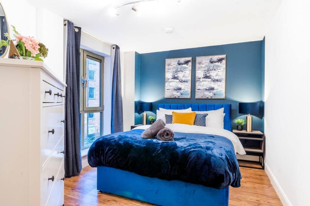 1 dormitorio azul con 1 cama con cabecero azul en Navy Retreat - 10 minutes walk to City Centre - Free Parking, Fast WiFi and Smart TV by Yoko Property, en Derby
