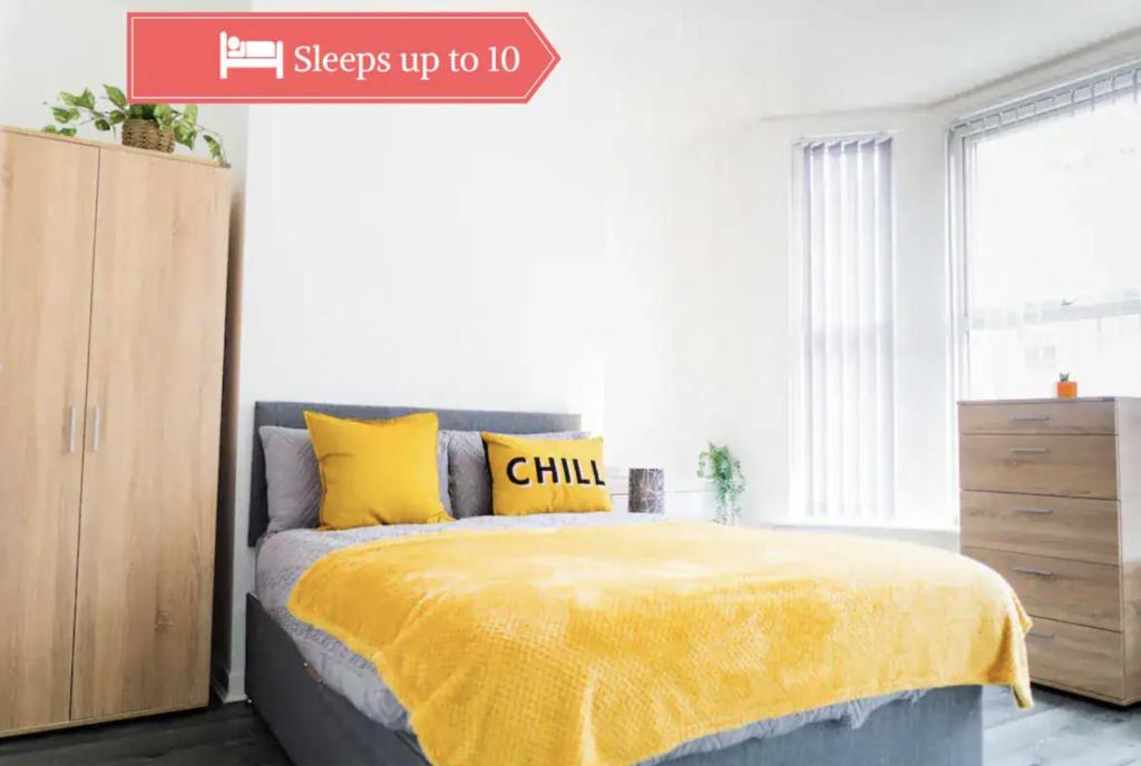 a bedroom with a bed with a yellow blanket at Bright 4BR Home, Perfect for Groups in Liverpool