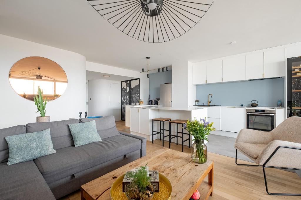 un salon et une cuisine avec un canapé et une table dans l'établissement Veeve - Riverside Heights, à Paris
