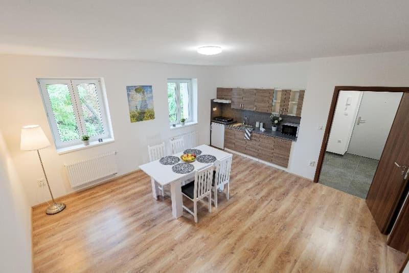 a living room with a white table and a kitchen at TVM Ostrava 1 in Ostrava