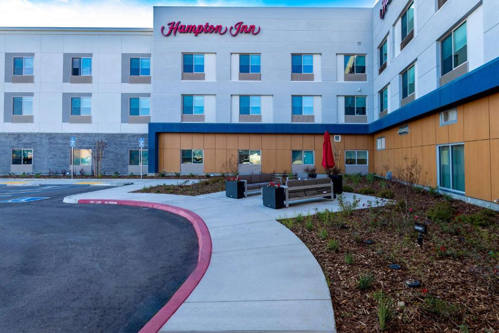 SelmaHampton Inn Selma, Ca的酒店大楼前面有人行道