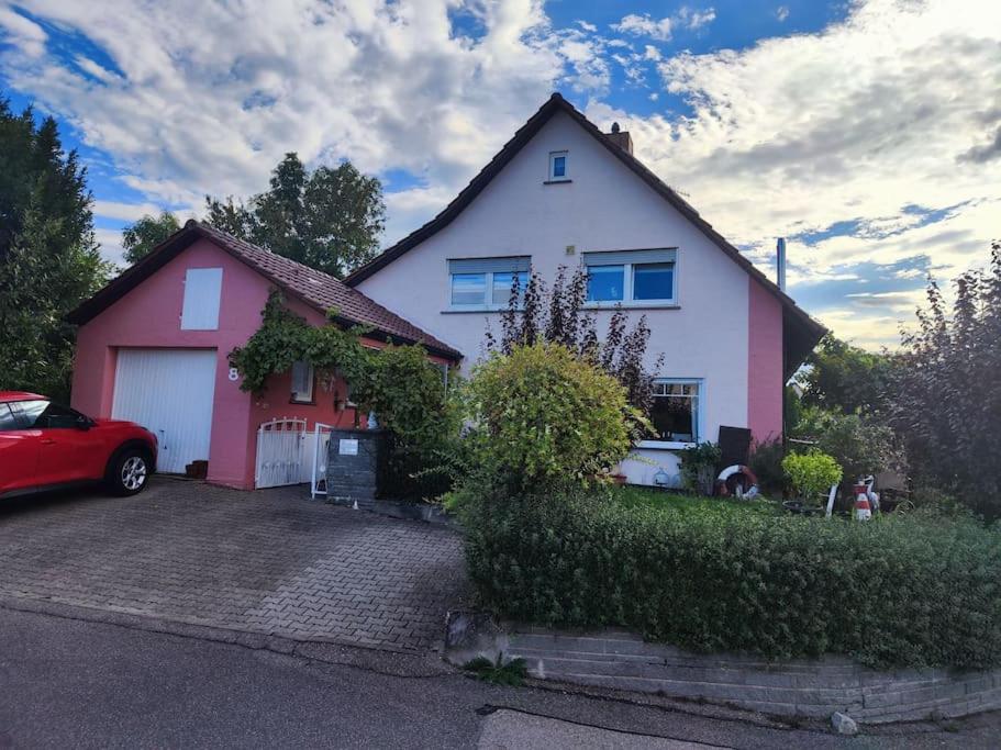 een huis met een rode auto op een oprit bij Spatzenbergzimmer 2 in Obersulm