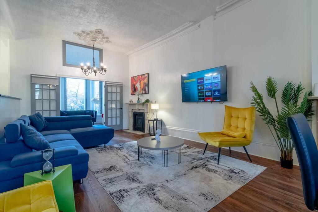 a living room with a blue couch and yellow chairs at Historical 5 Bedroom Villa that sleeps 12 guests with Patio, Fireplace, Grill and FREE parking in Chicago