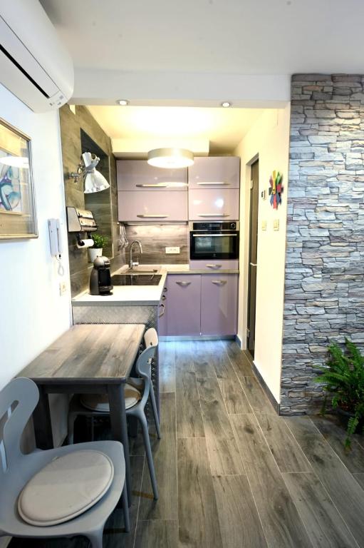 a kitchen with a wooden table and some chairs at Bel-Art in Hvar