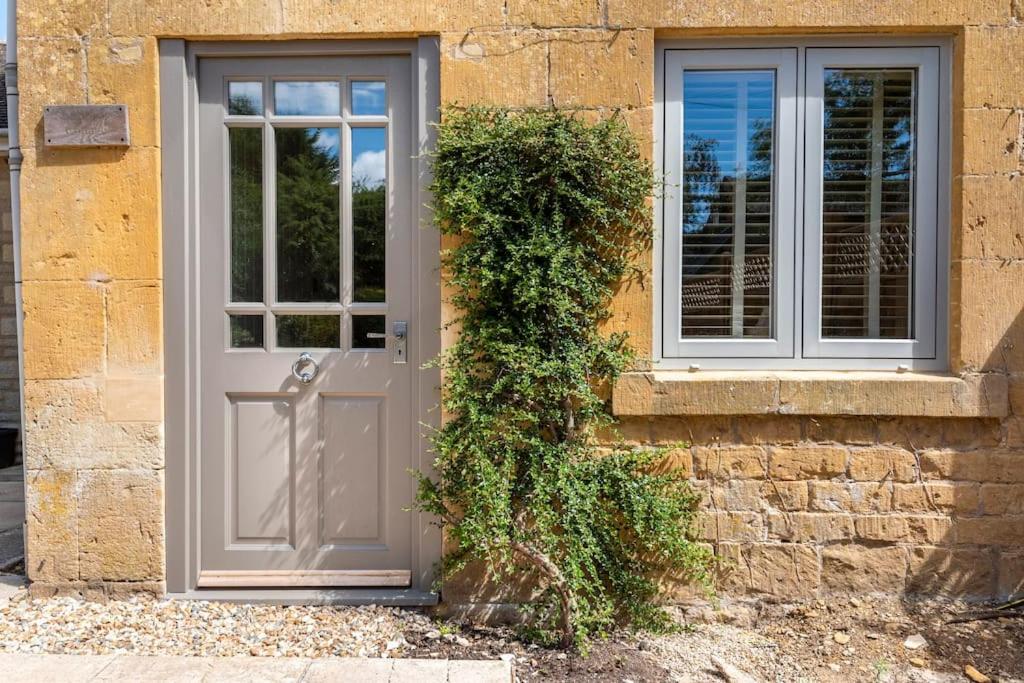 a door and a window on a brick building at Idilic Cottage The Sheaf in Blockley