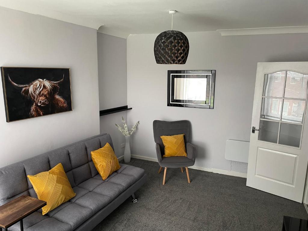 a living room with a couch and a chair at Bellshill , Belvidere central upper apartment in Bellshill