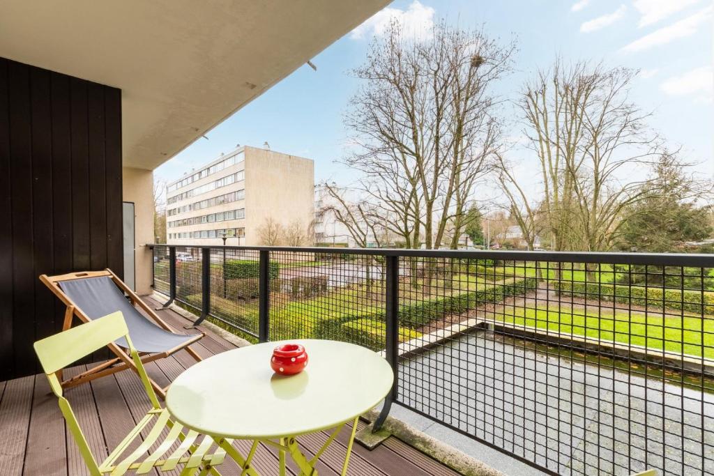 d'un balcon avec une table, des chaises et une piscine. dans l'établissement Tourcoing - Nice apartment for 4 parking, à Tourcoing