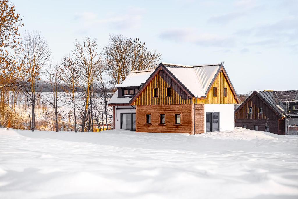 a wooden house in the snow in a field at Roubenka "Tam kde lišky dávají dobrou noc" in Černý Dŭl