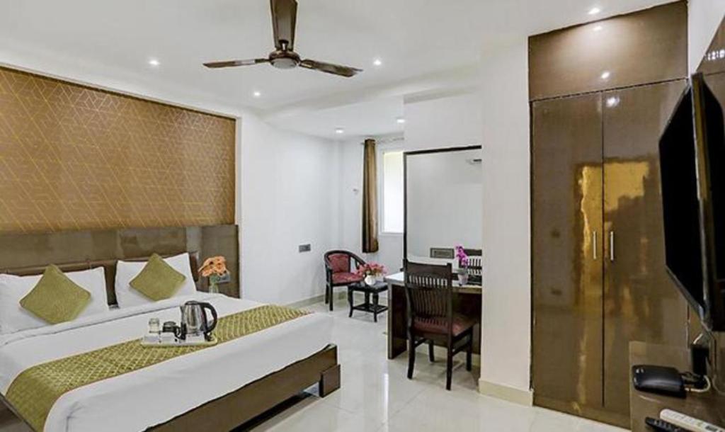 um quarto com uma cama grande e uma secretária em FabHotel 19 West em Nova Deli