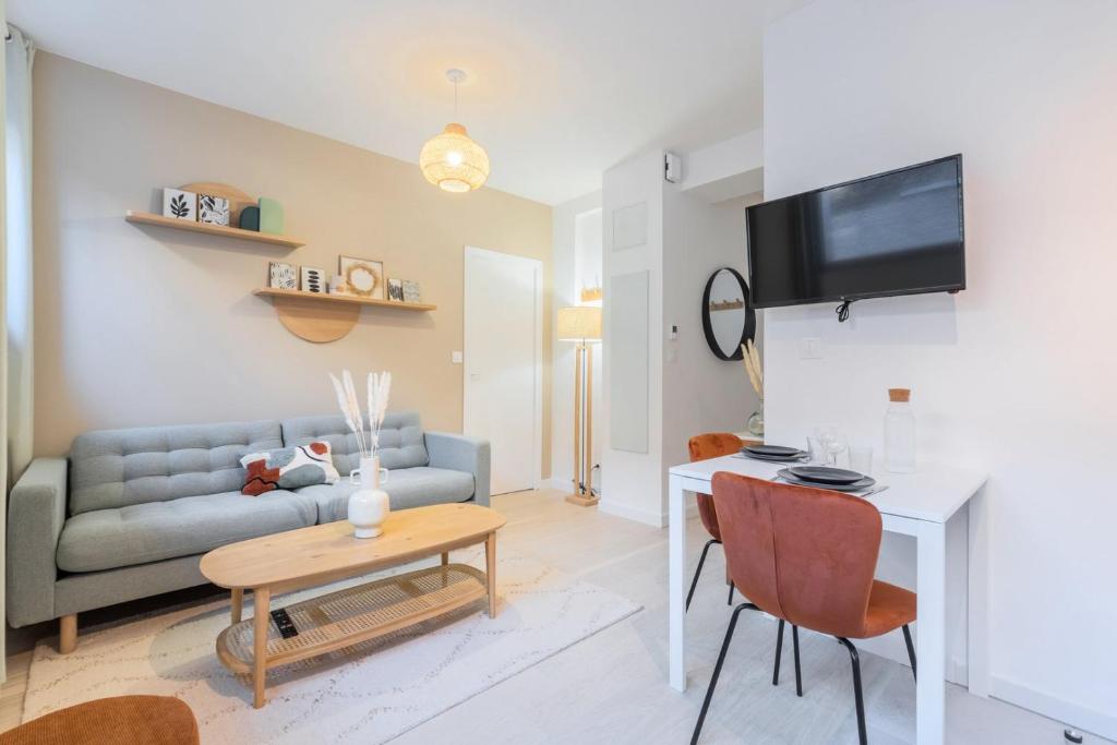 un salon avec un canapé et une table dans l'établissement Renovated 1 bedroom apartment, à Lille