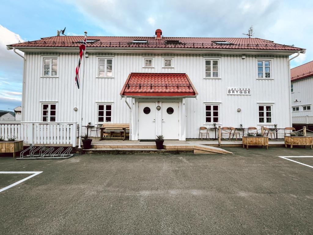 a large white building with a red roof at Lødingen Brygge in Lødingen