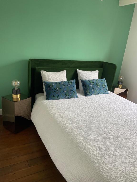 - une chambre avec un grand lit et des oreillers bleus dans l'établissement Villa Yollande, à Arcachon