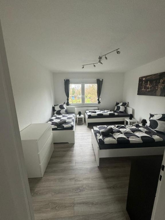 een woonkamer met 3 bedden en een bank bij Wohnglück 2 in Herten