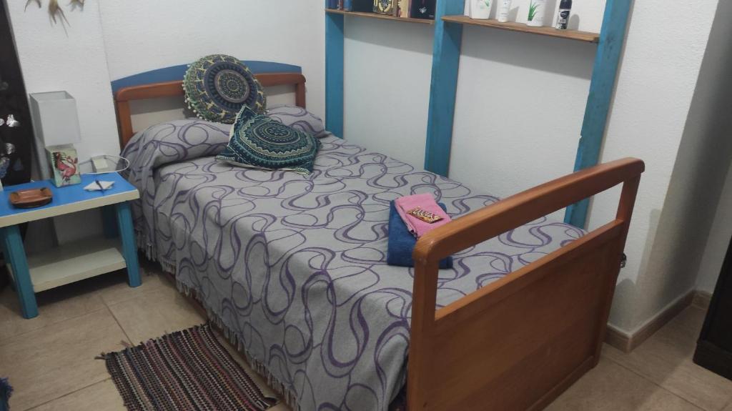 uma pequena cama num quarto com uma mesa em Laurainu em Puerto del Rosario